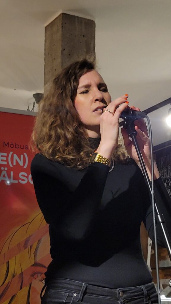 Lebe(n) unverfälscht im Bioladen: Melanie Möbus beim Singen mit geschlossenen Augen.